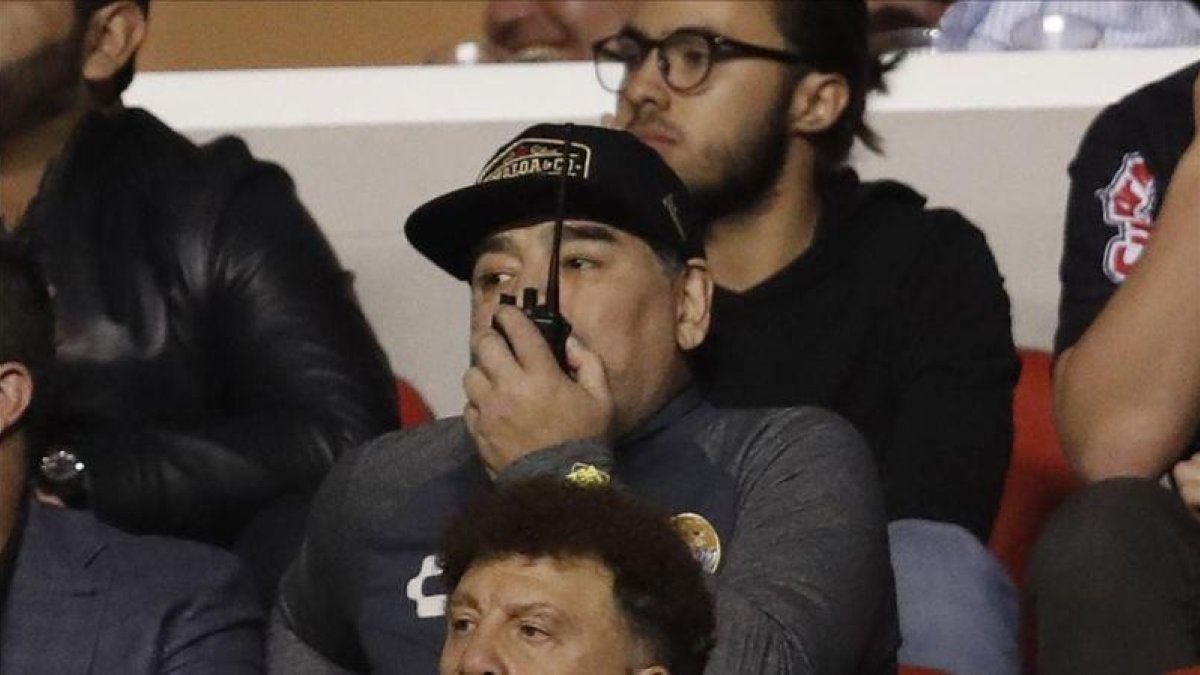 Maradona sigue el partido de su equipo desde el palco.
