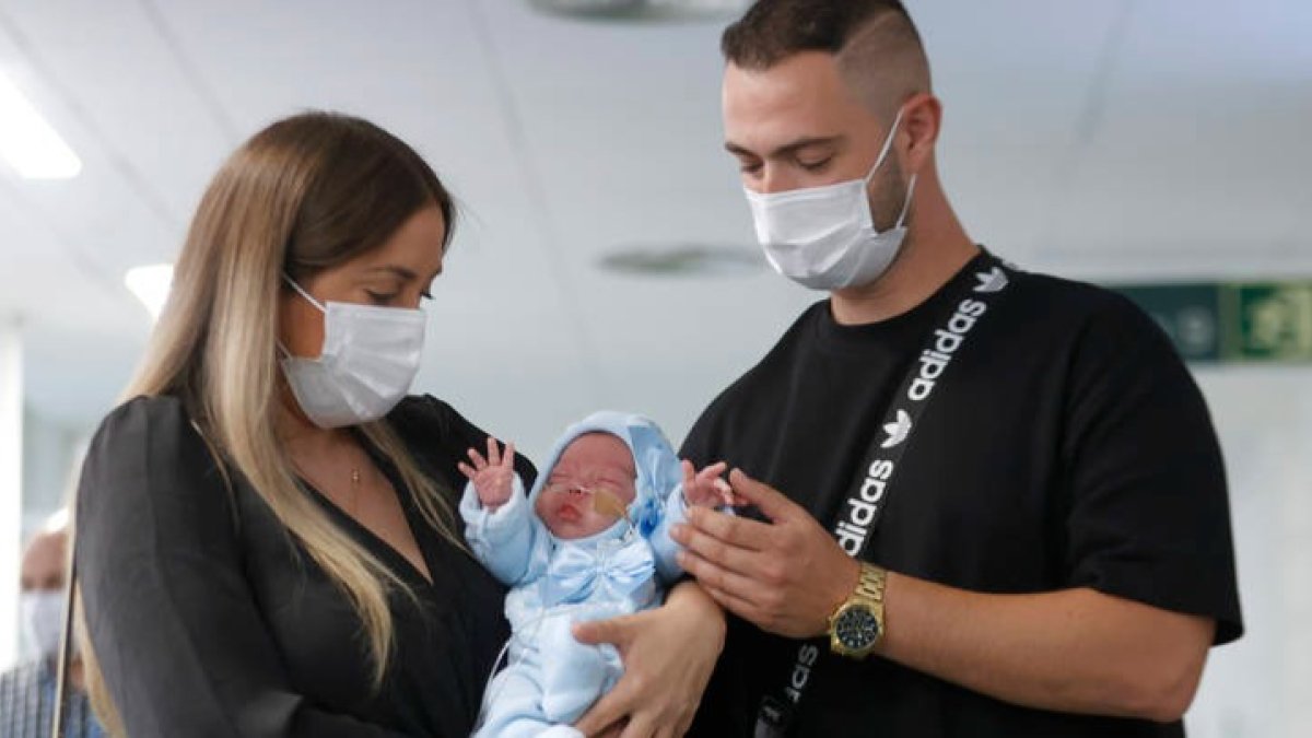 La pareja formada por Tamara y Jesús posan con su hijo, el pequeño Jesús, que se ha convertido en el primer bebé nacido en España de una mujer trasplantada de útero. TONI ALBIR