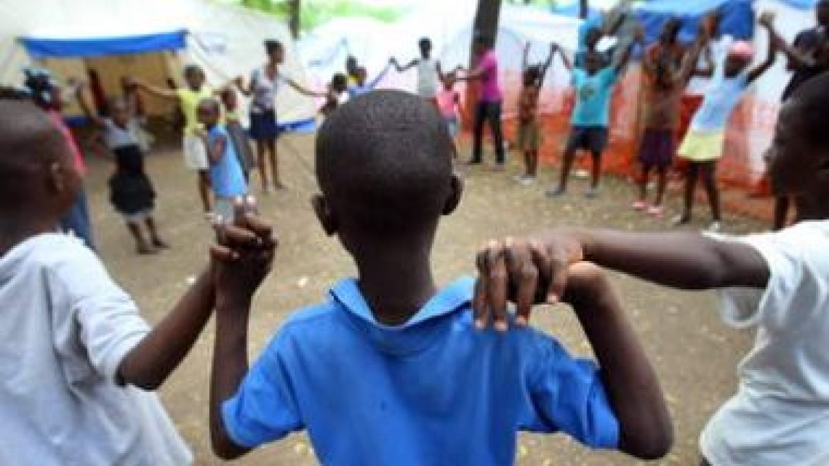 Un grupo de niños juega en un área infantil instalada por Save the Children en el campo Delmas, en P