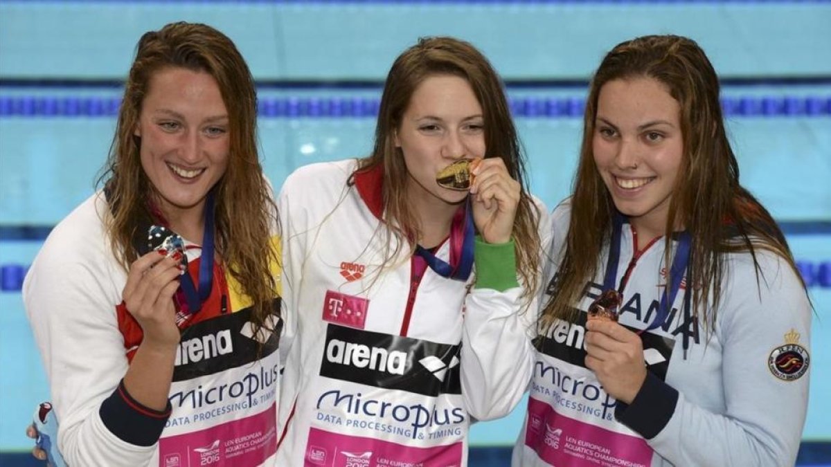 Mireia Belmonte (izquierda, plata) y María Vilas (derecha, bonce) flanquean a la húngara Boglarka Kapas tras recibir sus respectivas medallas en la prueba de los 1.500 metros libre en los Campeonatos de Europa de Natación de Londres.