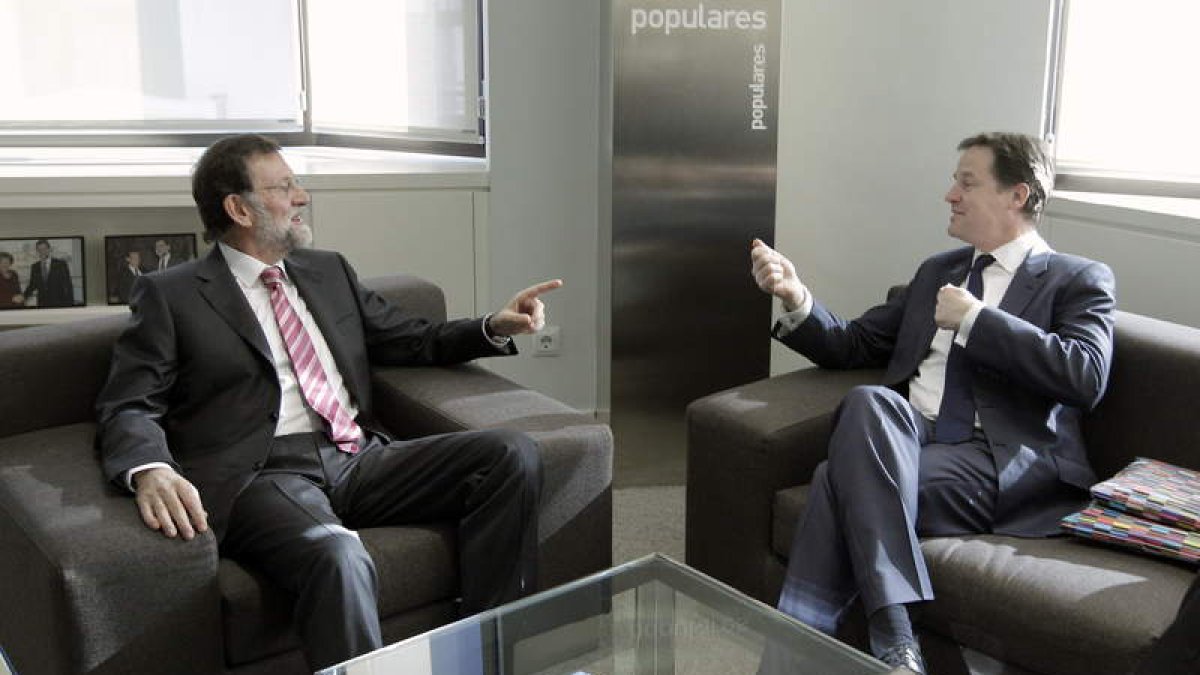 Rajoy conversa con Nick Clegg, en la reunión celebrada en la sede central del partido.
