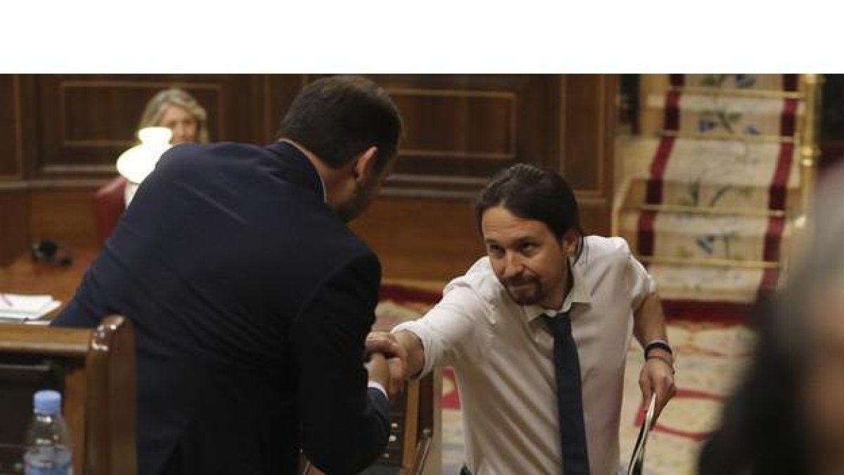 El líder de Podemos, Pablo Iglesias (d), y el portavoz del PSOE, José Luis Ábalos, se estrechan la mano durante la segunda jornada del debate de la moción de censura de Unidos Podemos contra el Gobierno de Mariano Rajoy, esta mañana en el Congreso