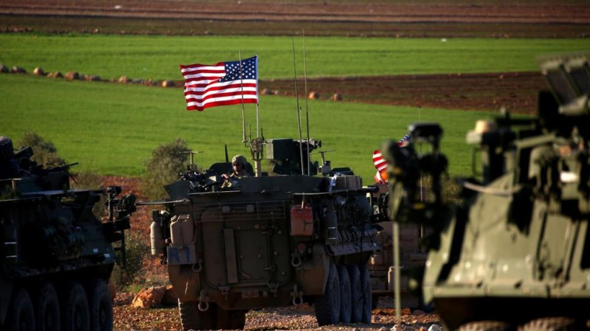 Un convoy de tanques con bande ra de EEUU circulan a las afueras de la ciudad de Manbij, al norte de Siria.