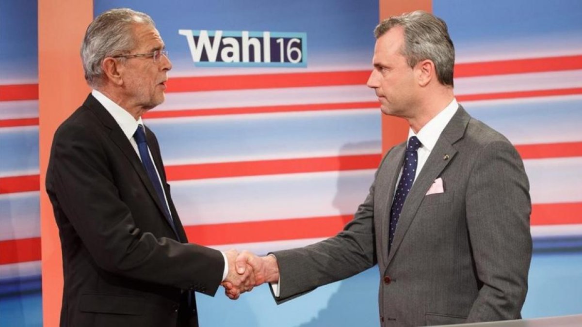 El candidato ecologista (izquierda), y el ultranacionalista (derecha), se dan la mano en un programa de televisión.