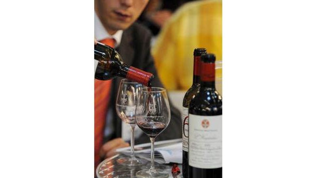 Una persona sirve una copa en Vinexpo 2009 en Burdeos.