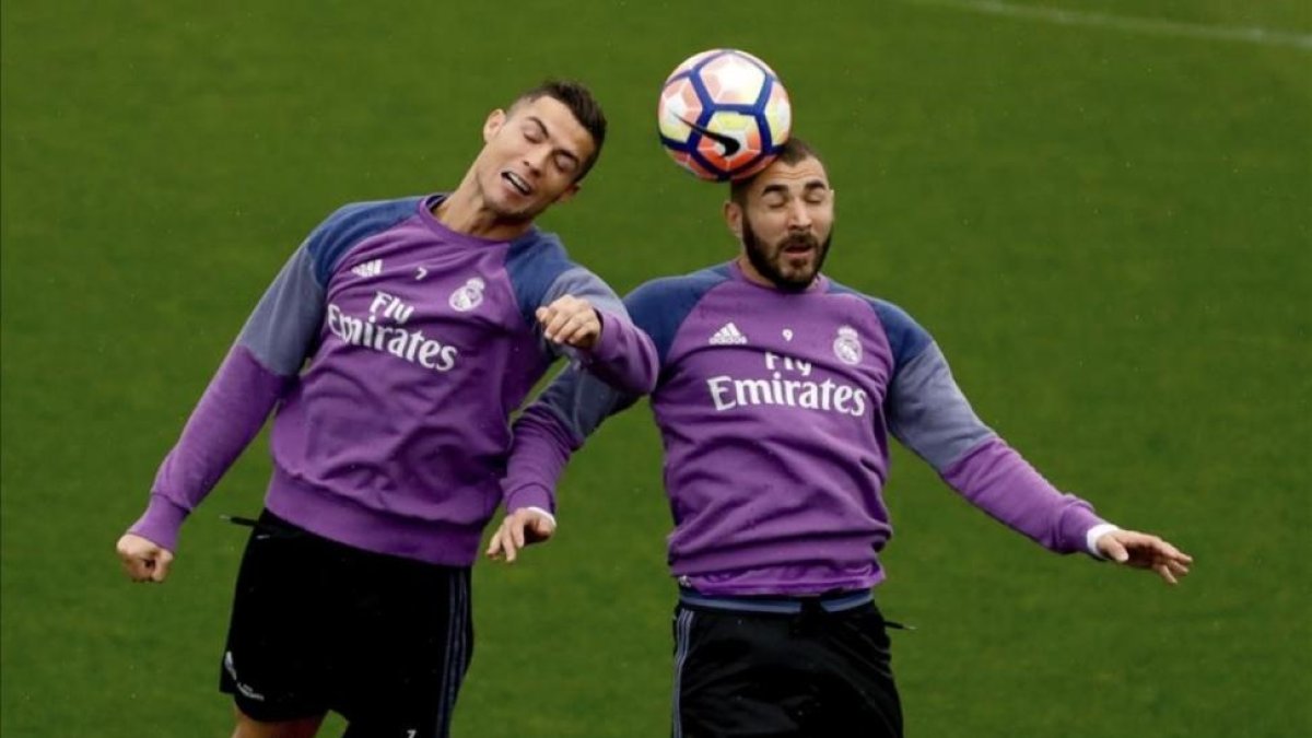 Cristiano Ronaldo y Benzema disputan el balón durante el entrenamiento de este sábado en la ciudad deportiva de Valdebebas.