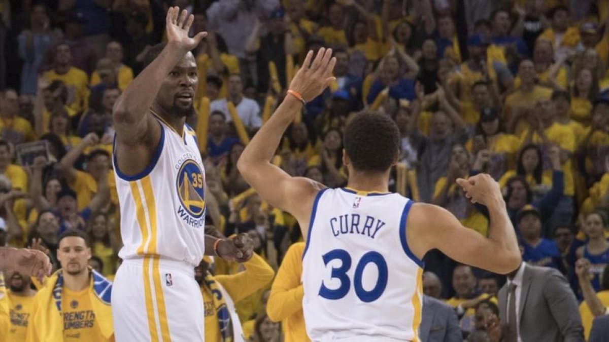 Durant y Curry se felicitan por la victoria ante los Spurs (113-111).