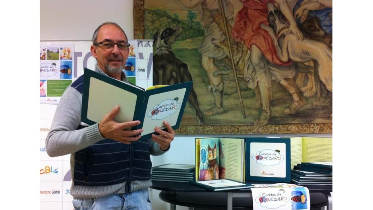 El presidente de Proyecto Hombre sostiene el libro de cuentos.