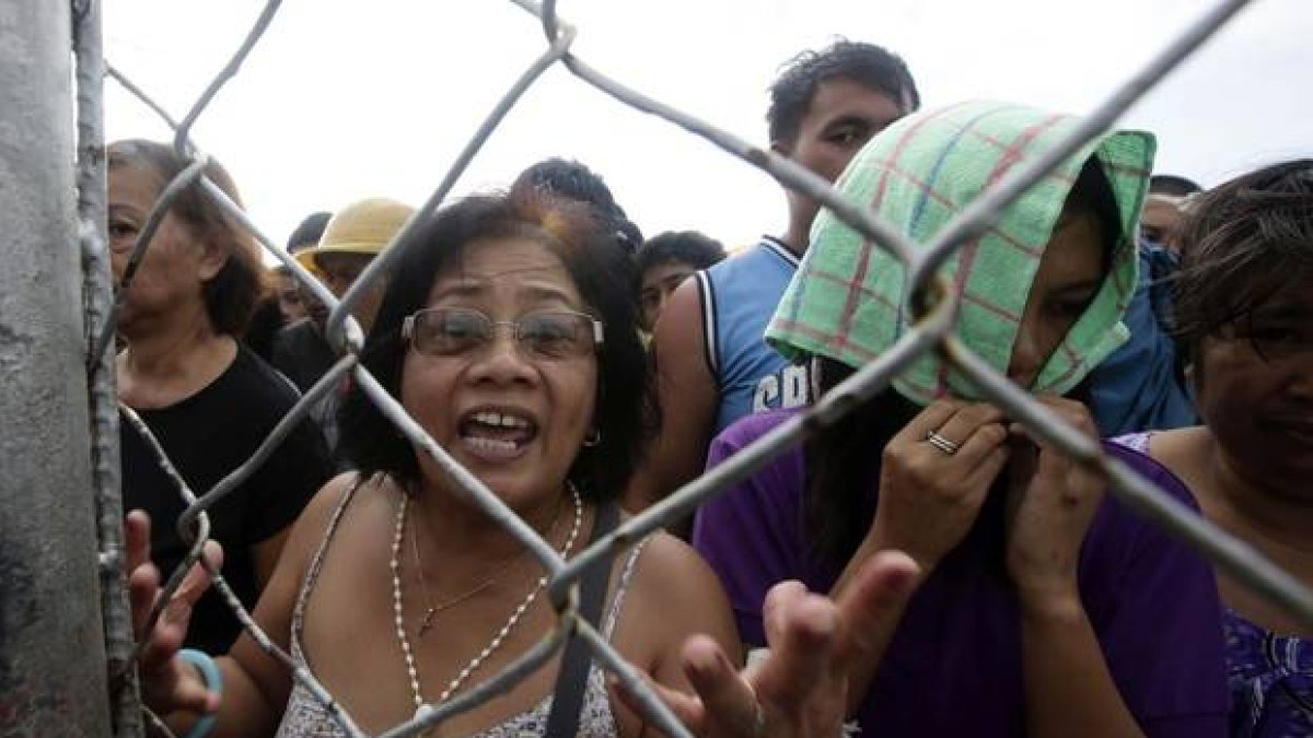 Decenas de persona esperan para recibir ayuda y ser evacuadas, en el aeropuerto de Tacloban.