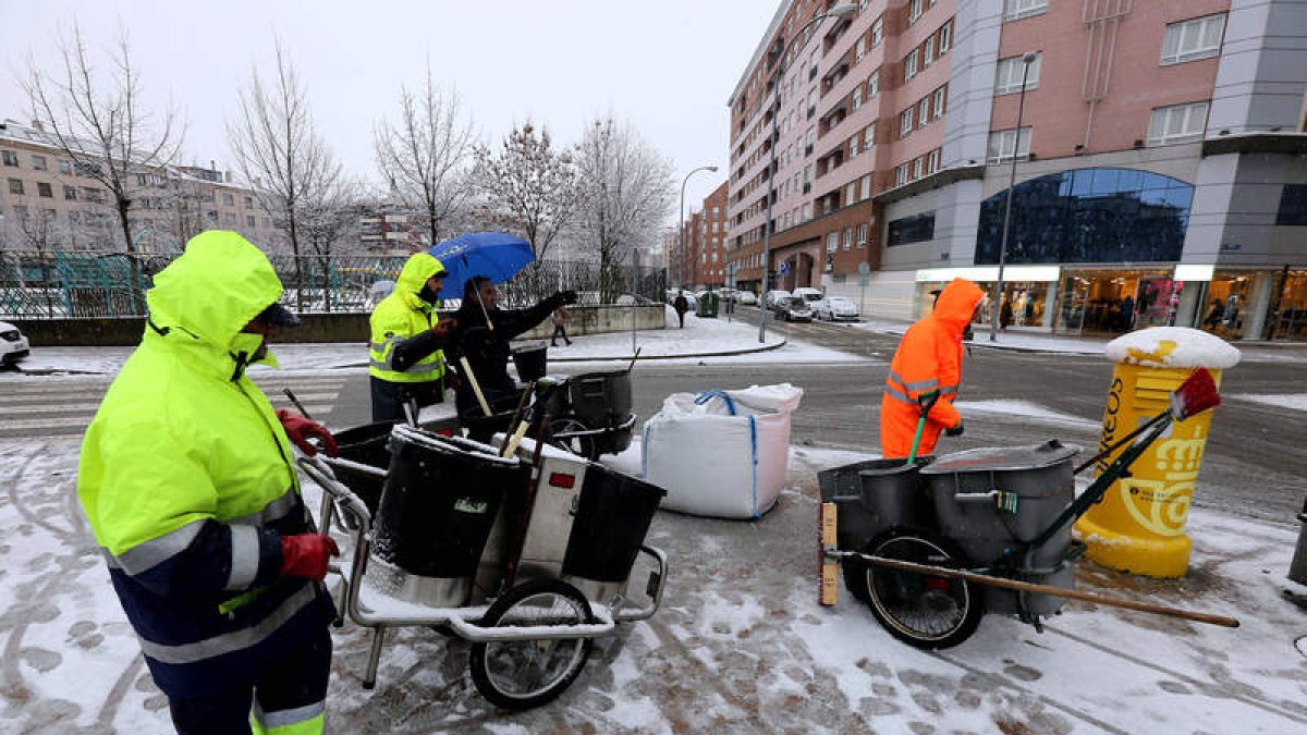 Operarios del servicio de limpieza de la capital esparcen sal en una nevada de febrero