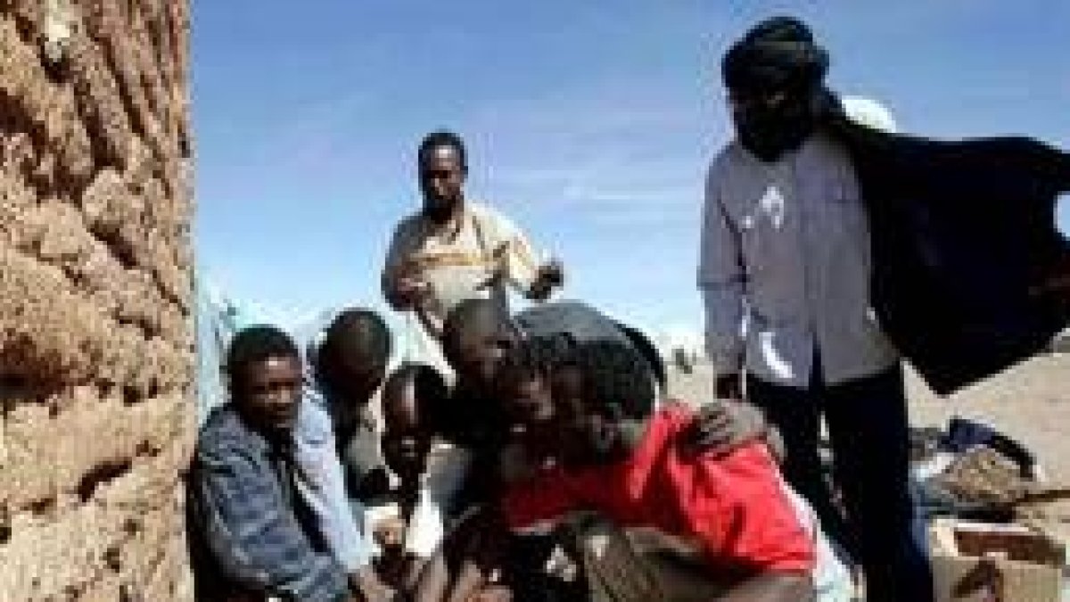 Un grupo de inmigrantes prepara la comida en el puesto saharaui en el que se han refugiado