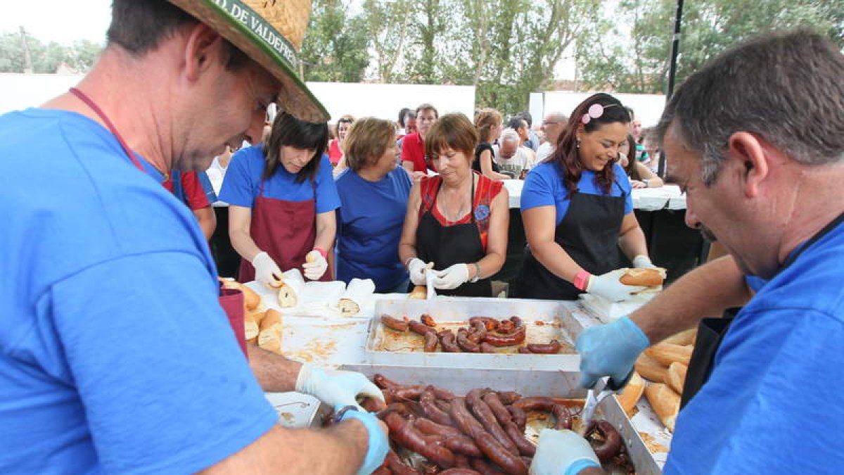 Foto, de una pasada edición de la fiesta, de los voluntarios que se afanan en la elaboración de los bocadillos de chorizo al vino.
