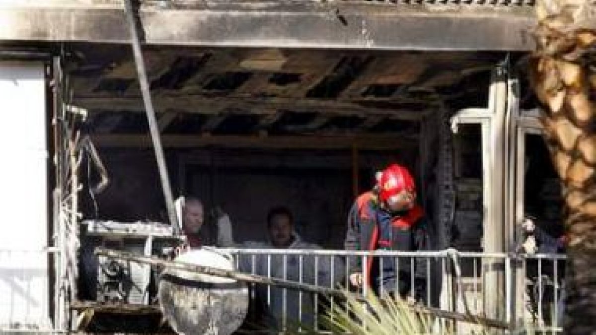 Los bomberos de Alicante y agentes de la Policía Judicial inspeccionan el apartamento siniestrado