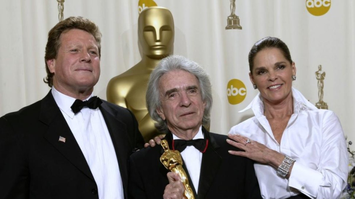 Arthur Hiller, con el Oscar, entre los protagonistas de 'Love Story' Ryan O'Neal y Ali McGraw.