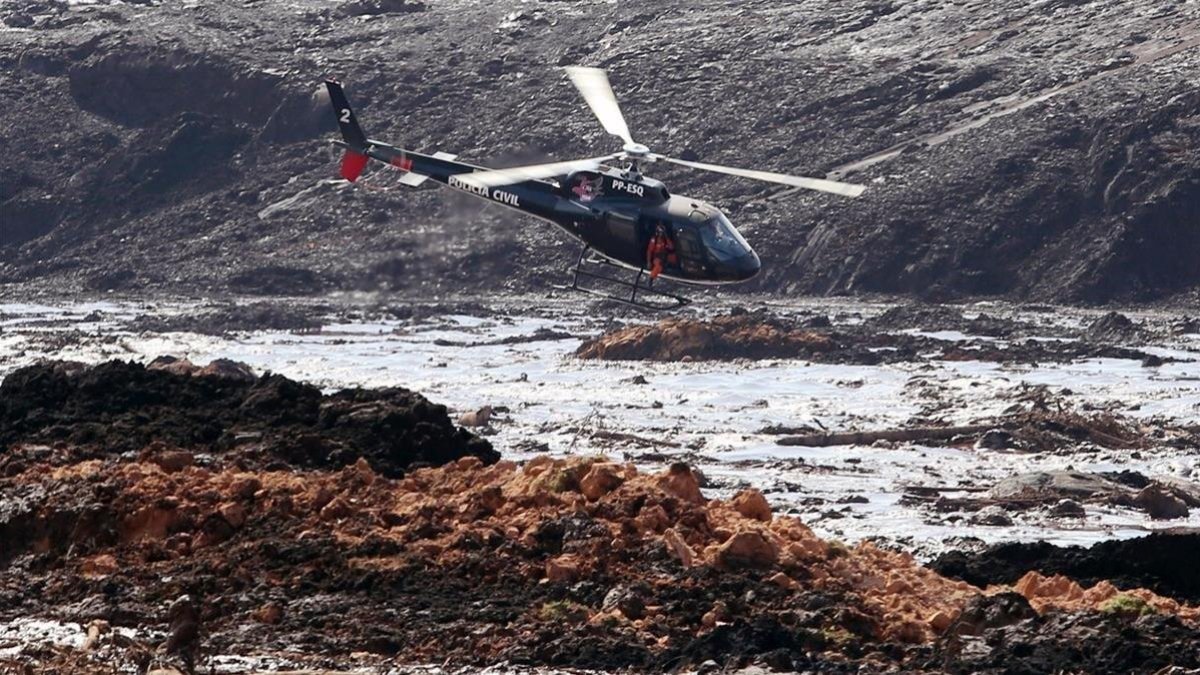 Un helicóptero busca supervivientes tras el desastre causado por la rotura de la represa que contenía residuos minerales de la compania Vale.