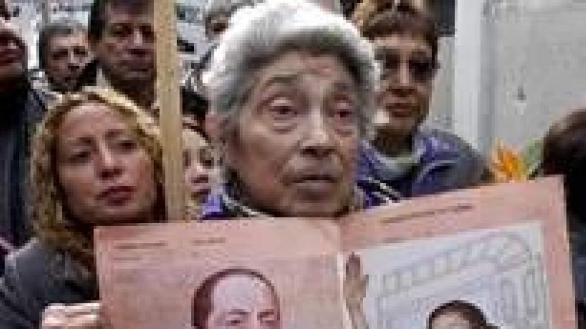 Una argentina sostiene la foto de Perón y de su esposa en el aniversario de su muerte