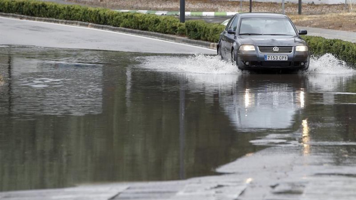 Un coche circula por una carretera inundada en Boadilla del Monte (Madrid)
