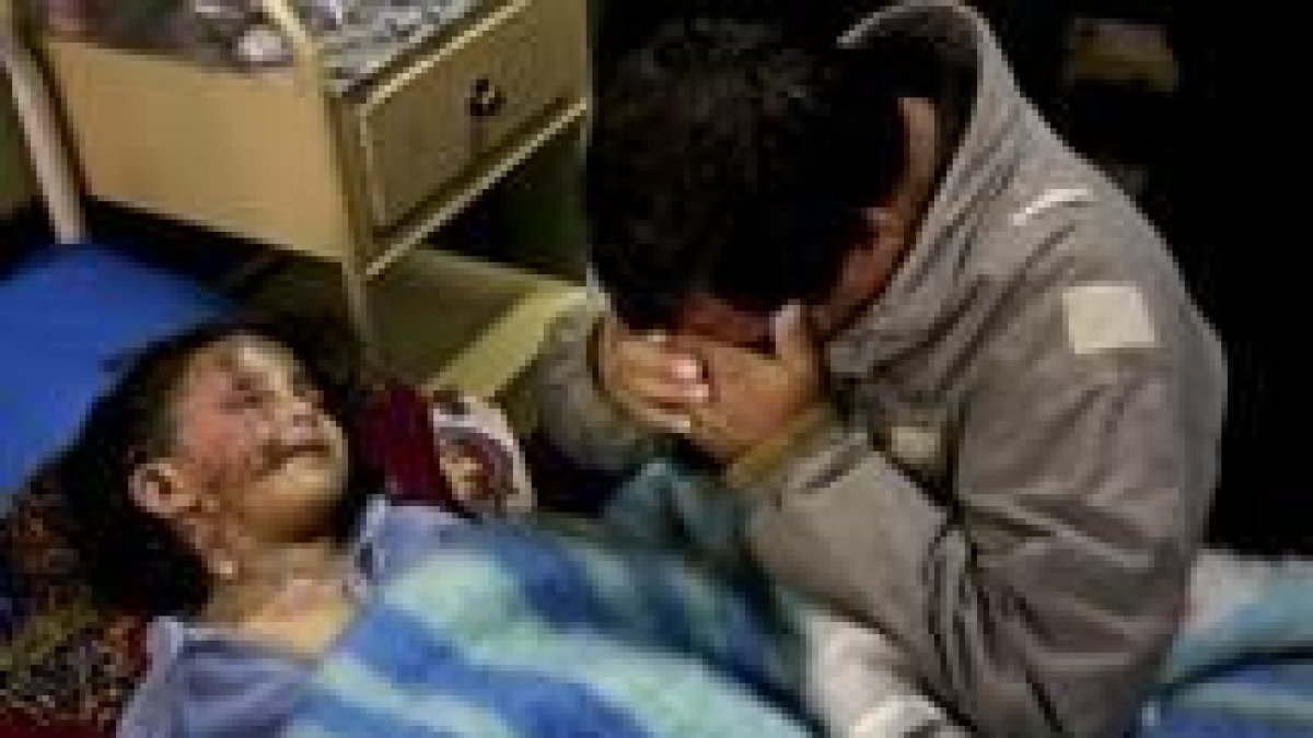 Un hombre iraquí llora junto a la cama de su sobrina, herida en un bombardeo sobre Bagdad