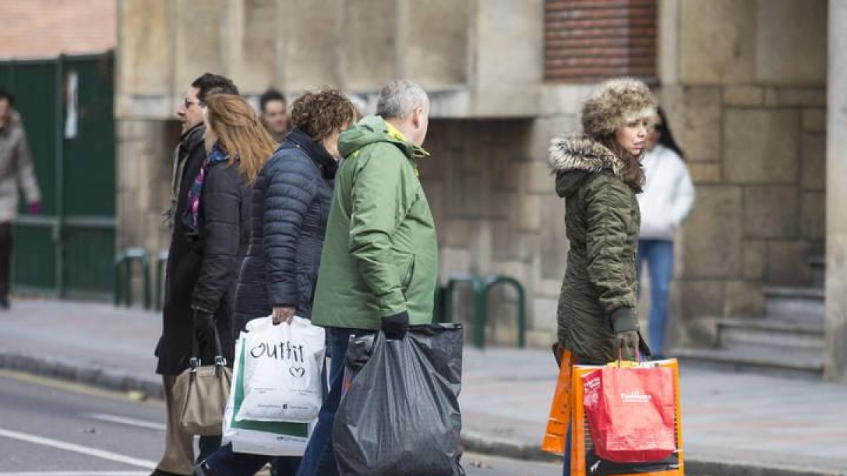 Varias personas llevan bolsas con compra durante una jornada de rebajas