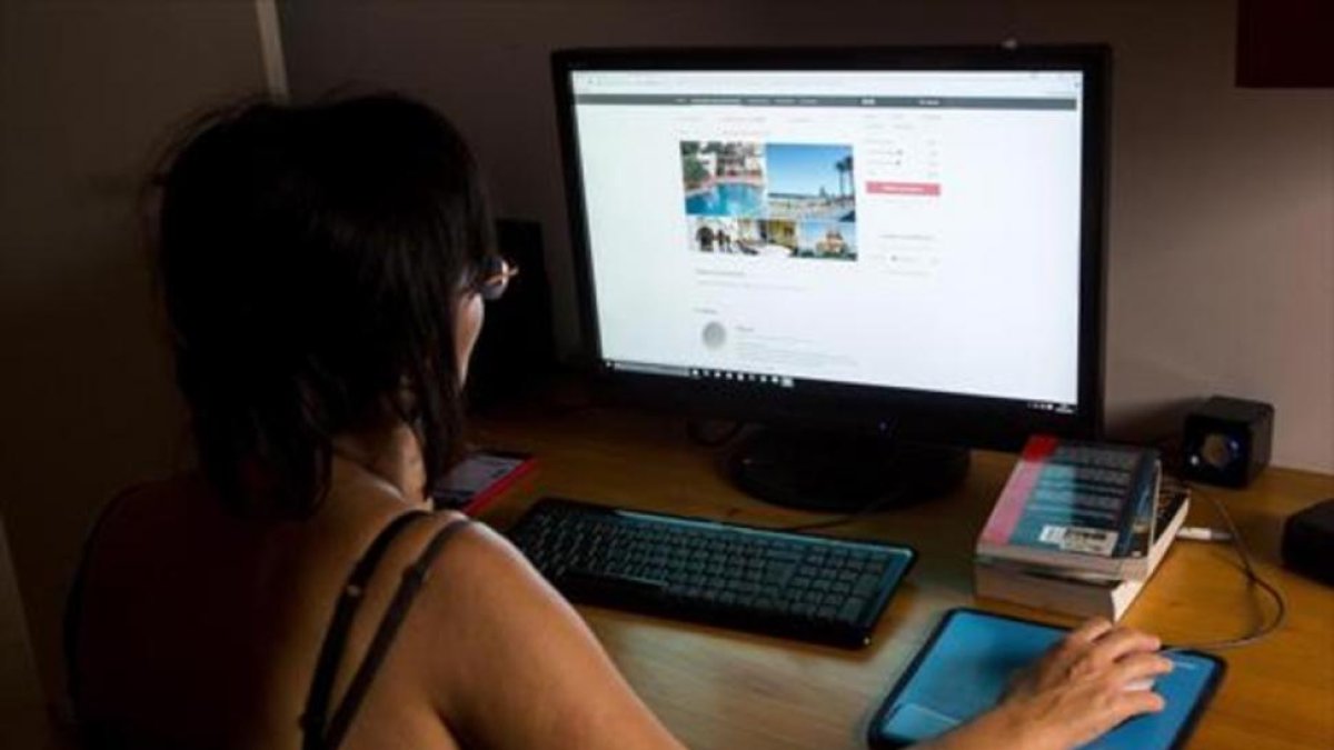 Una mujer consulta la plataforma on line Airbnb