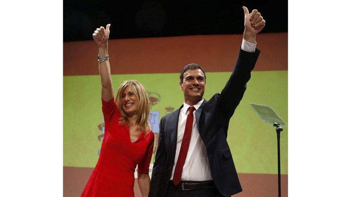 Pedro Sánchez, acompañado de su mujer, Begoña Gómez, al fondo una gran bandera de España