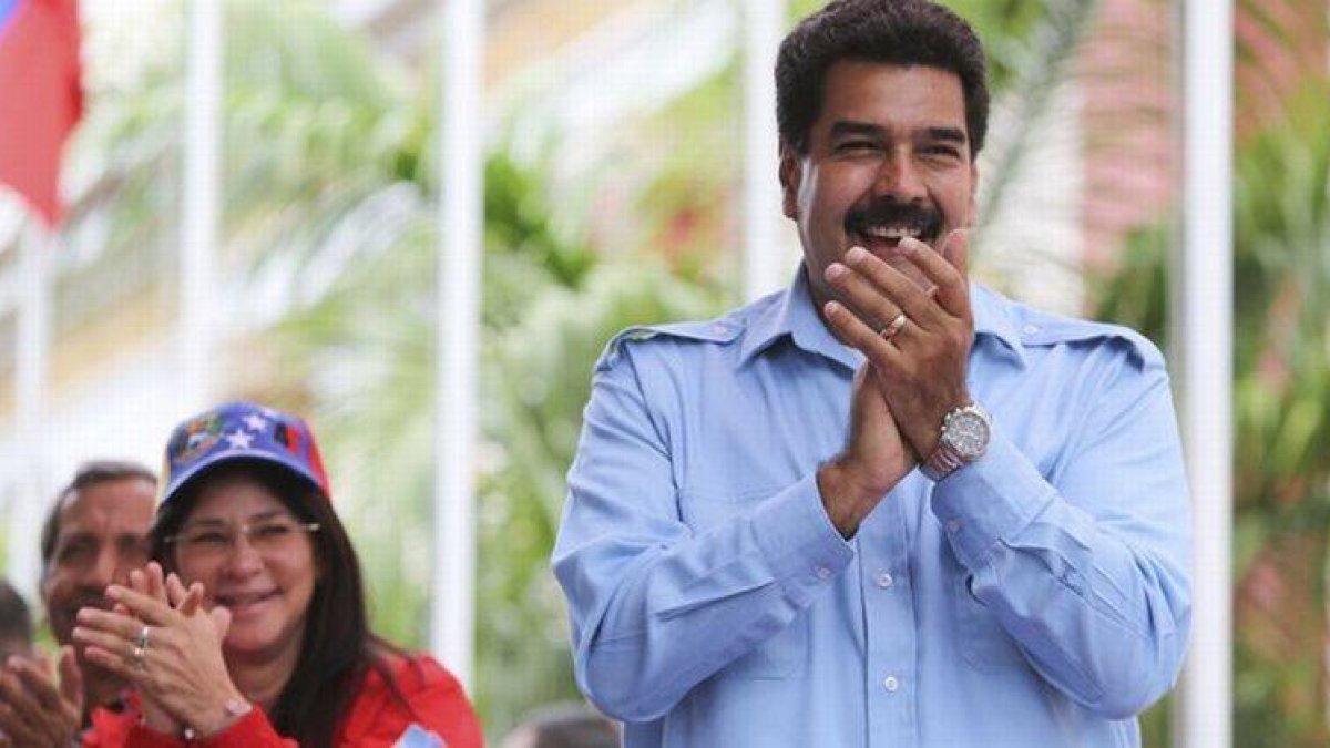 Nicolás Maduro, acompañado por su esposa, se dirige a simpatizantes, durante una marcha en Caracas, este domingo.