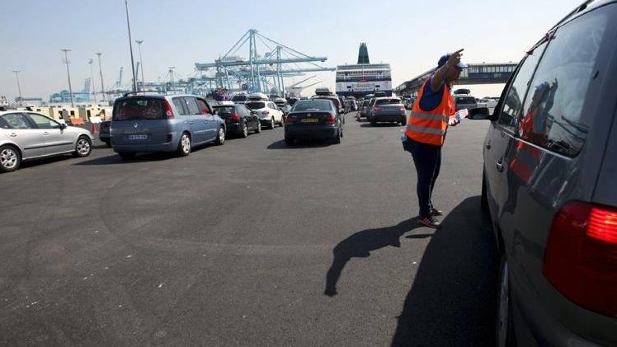 Una trabajadora indica a uno de los viajeros su zona de embarque hoy en el puerto de Algeciras, durante la Operación Paso del Estrecho.