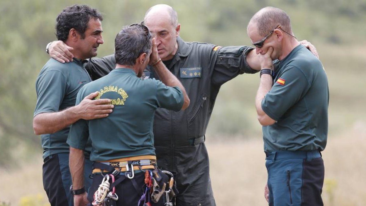Compañeros de los guardias civiles fallecidos se abrazan desconsolados durante el rescate