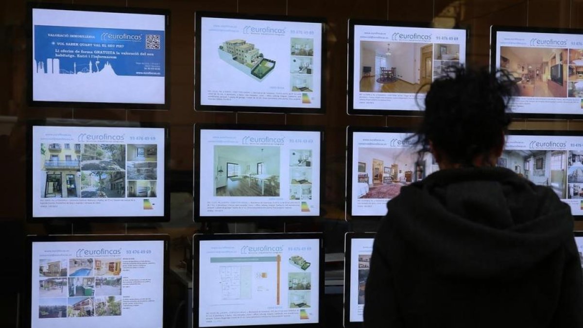 Ofertas de ventas de pisos en el escaparate de una inmobiliaria