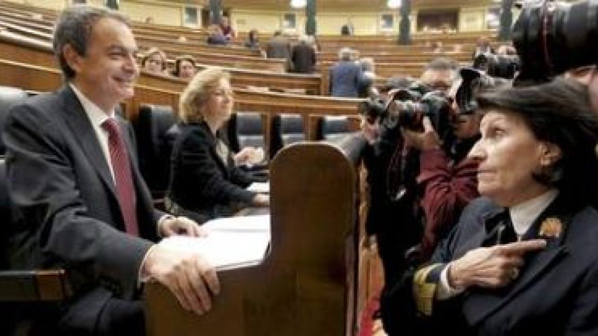 Zapatero charla con una ujier del Congreso antes del comienzo de la sesión de control al Ejecutivo.