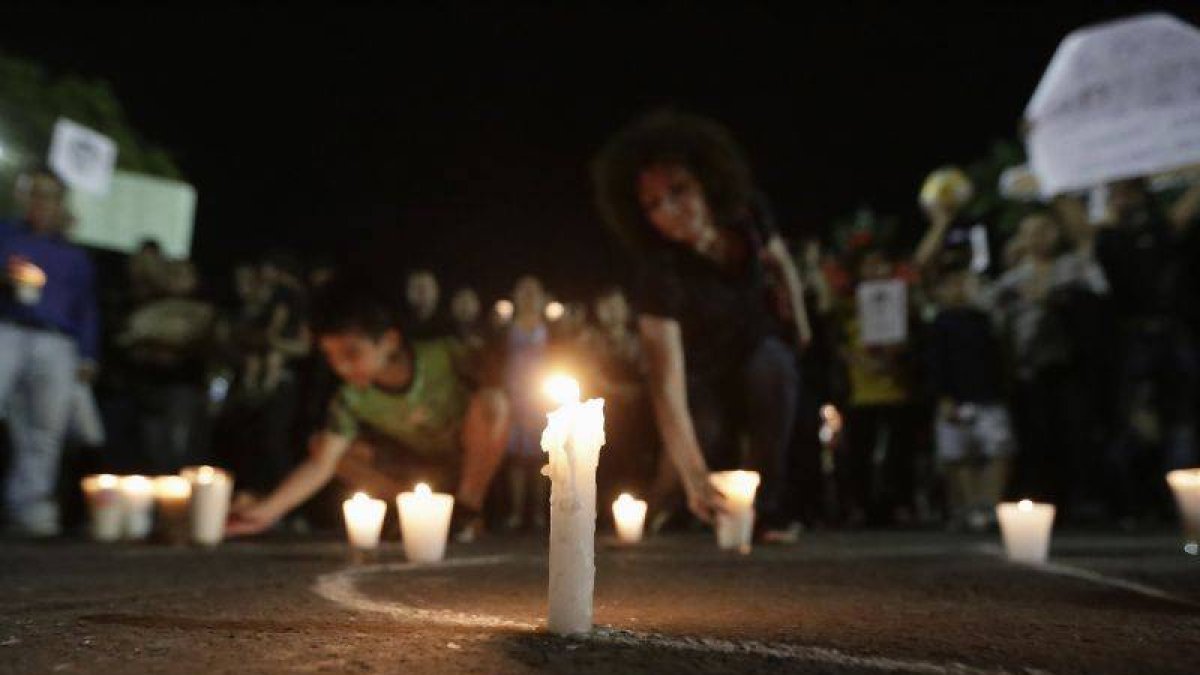 Los mexicanos colocan velas para homenajear a los estudiantes asesinados.