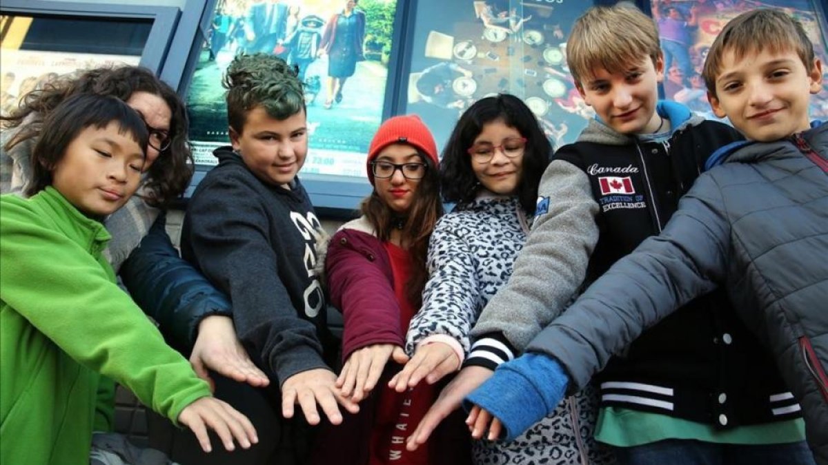 Un grupo de niños, algunos de ellos con fisura labial, juntan sus manos antes de entrar en el cine para ver la película Wonder, el domingo pasado en Cerdanyola.