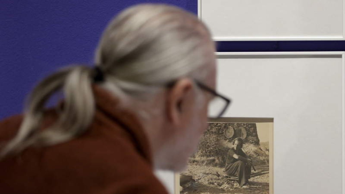 Un visitante contempla una foto de Rahola. A la derecha, imagen de gente en la cola del pan (1936-37). QUIQUE GARCÍA / HEREDEROS DE MEY RAHOLA