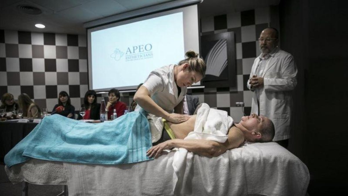 Una fisioterapeuta muestra cómo dar un masaje a una enferma de cáncer.