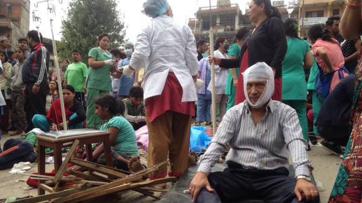 Algunos heridos reciben tratamiento en las puertas del Hospital de Katmandú.