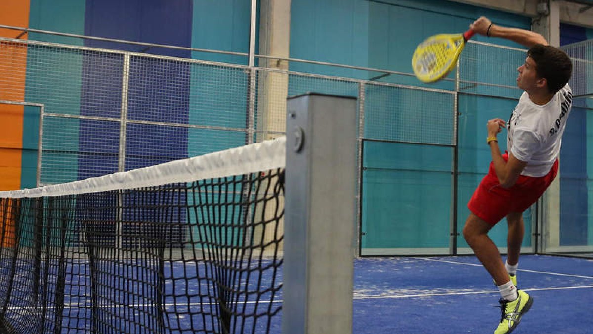 Un jugador realiza un remate en la red en una de las instalaciones cubiertas que permiten la práctica del pádel en León.