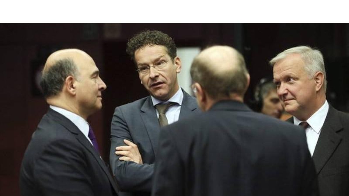 El ministro francés de Finanzas, Pierre Moscovici (izquierda), conversa con el presidente del Eurogrupo, Jeroen Dijsselbloem, y el comisario Olli Rehn, antes del inicio de la reunión de ministros de Finanzas de la UE, este viernes.