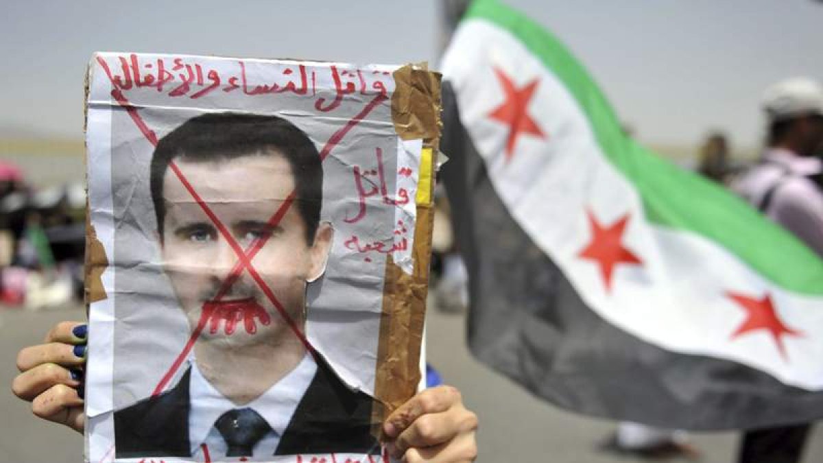 Un manifestante porta una pancarta en contra del presidente sirio.