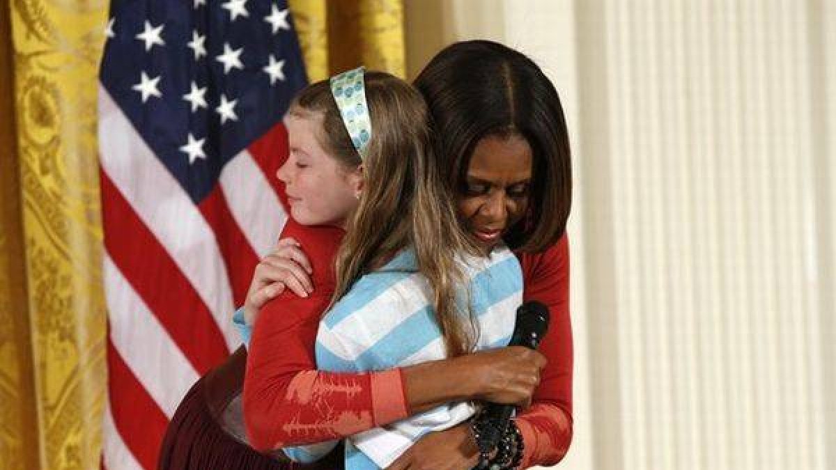 Momento en que la niña se funde en un abrazo con Michelle Obama.