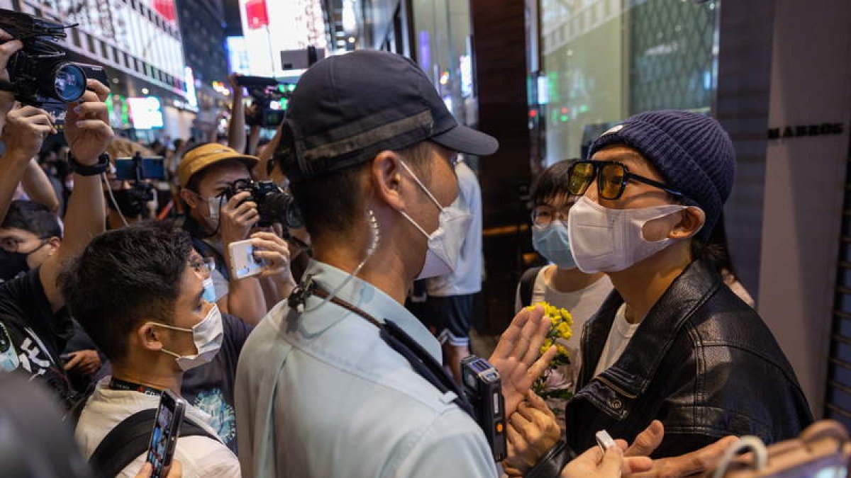 La policía advierte a los manifestantes durante una vigilia contra el régimen chino. JEROME FAVRE