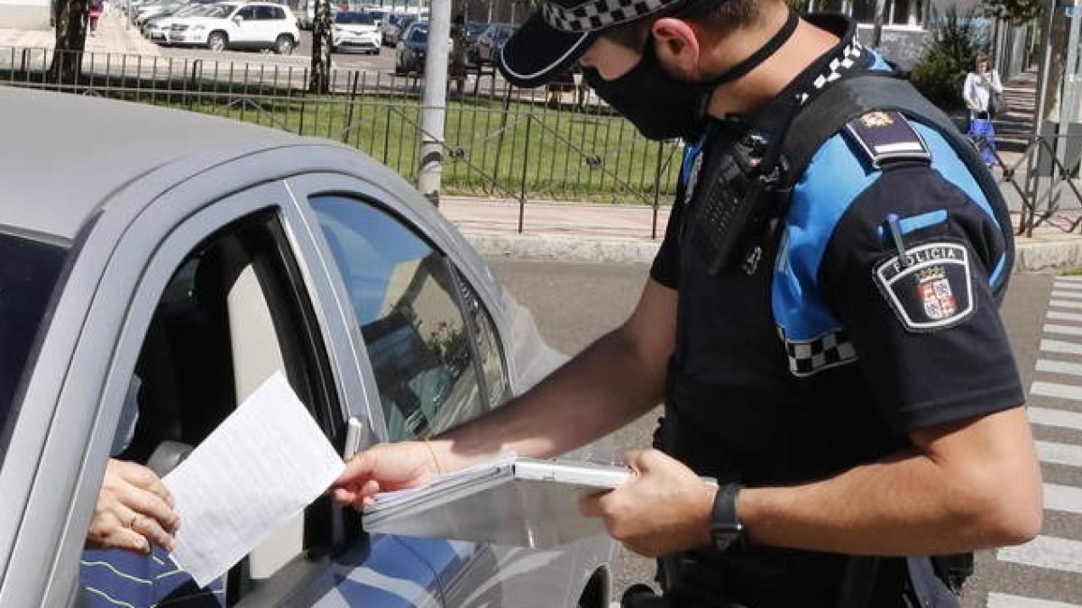 Un agente de la Policía Local sanciona a un conductor. DL