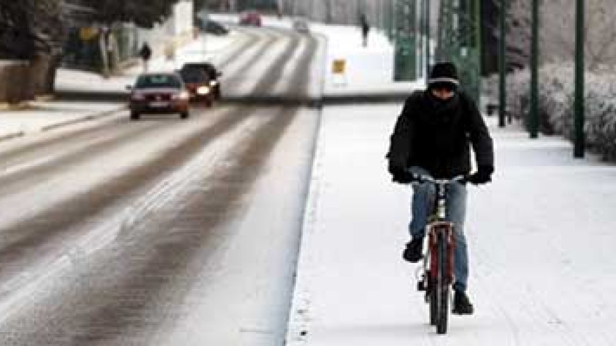 Un ciclista se aventura sobre las aceras cubiertas de hielo de Valladolid.