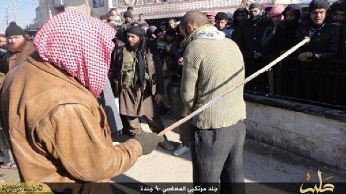 Un yihadista antes de comenzar a azotar a uno de los músicos.