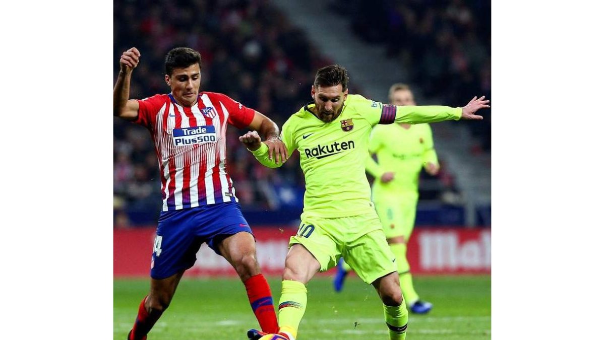 El rojiblanco Rodrigo y el azulgrana Messi luchan por el control del balón. RODRIGO JIMÉNEZ