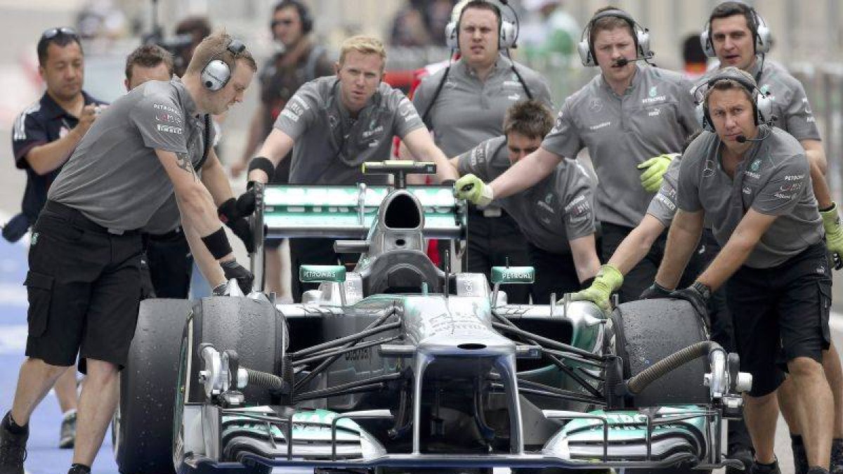 Mecánicos de Mercedes empujando el coche de Hamilton.