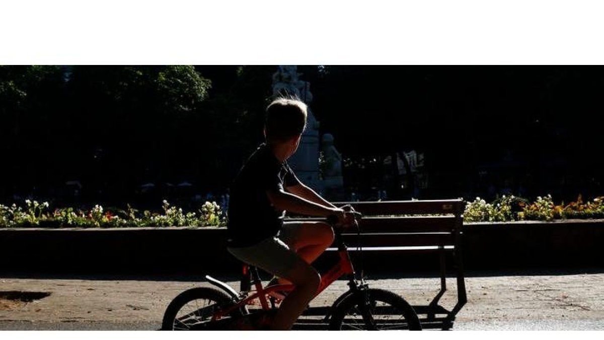 Un niño pasea en bicicleta por un parque de León. FERNANDO OTERO