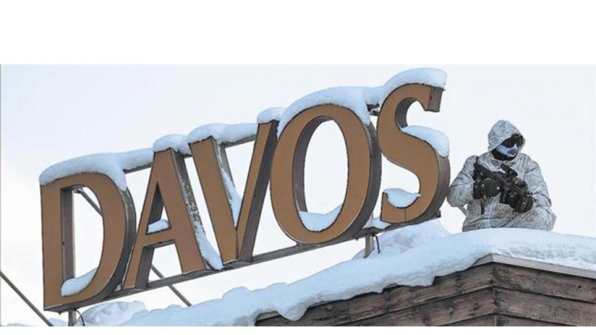 Un policía vigila desde un tejado en la víspera de la inauguración del 47º Foro Económico Mundial de Davos (Suiza), que comienza hoy.