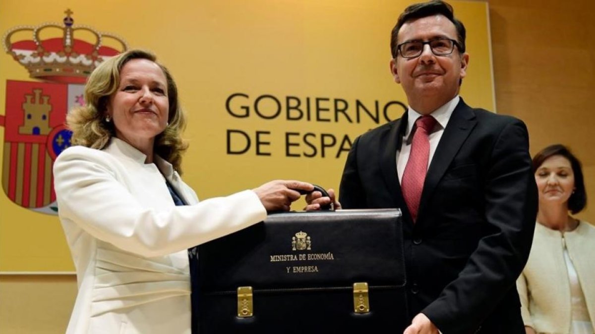 La nueva ministra de Economía, Nadia Calviño, recibe la cartera ministerial de manos de su antecesor en el cargo, Román Escolano.
