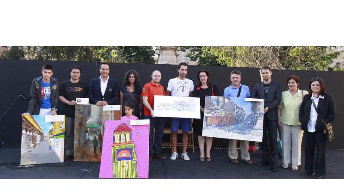 Los ganadores del certamen de pintura rápida posan con las obras en la plaza de San Marcelo.
