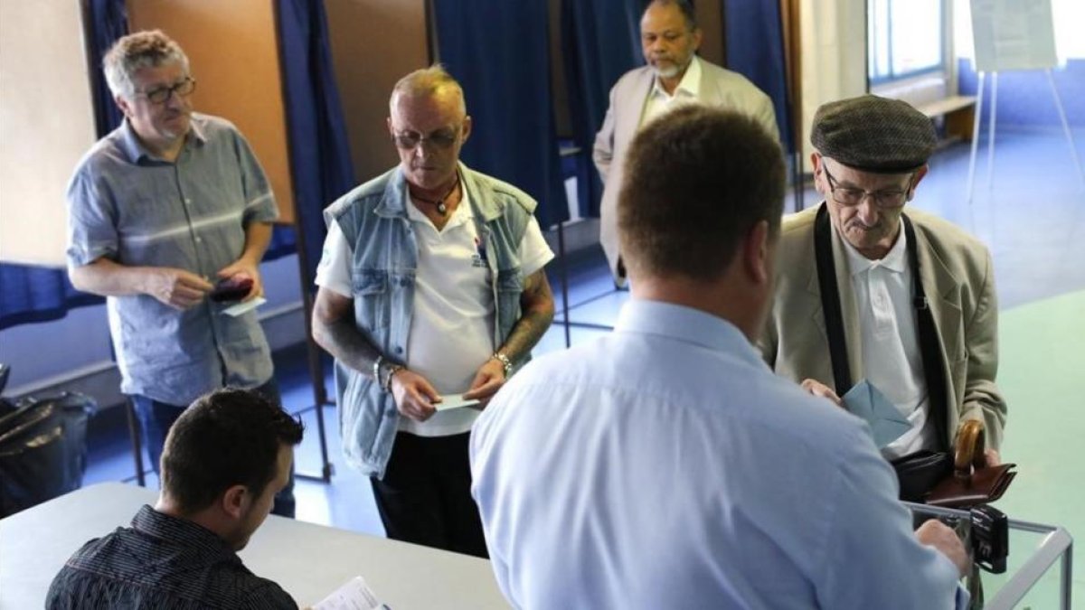 Un hombre introduce su papeleta en la urna en la segunda vuelta de las legislativas, en Henin-Beaumont (norte de Francia), el 18 de junio.
